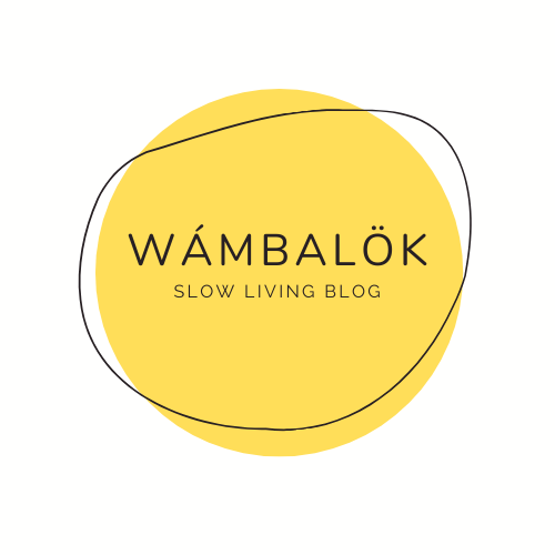 Logo compuesto por un círculo amarillo en el fondo, un borde circular en color negro, con el texto que lee Wámbalök, slow living blog.